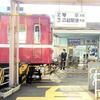 一宮駅の踏切を通過する情熱の赤い電車