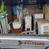 処分するエアコンの上に現場の道具を積み、