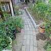 レンガの小道　エアコン室外機の木製カバー（飾り台＆作業台）とスッキリしたニンニク畑