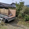 軽トラックの荷台の幌をあげ、コンパネを