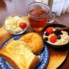 今日の朝食ワンプレート、チーズトースト、あんドーナツ、紅茶、キャベツサラダ、いちごバナナブルーベリーシリアルヨーグルト