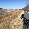 自転車で川沿いの土手を走る