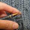１．３玉：棒針で編んだ灰色の幅細の縄編みスヌード
