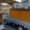 スタッフの軽トラックには、家具と袋ゴミ。